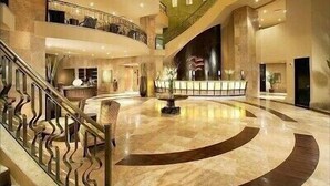 A spacious lobby with a central fountain, a curved marble floor, and a staircase leading to an upper level. - A View from the Top!  Las Palomas Penthouse Level Beachfront Luxury Condo!!! (Puerto Penasco)