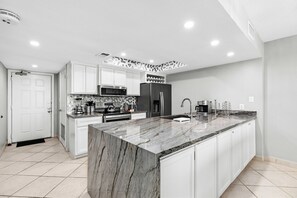Enjoy cooking in this well-equipped kitchen with a large island and stainless steel appliances.