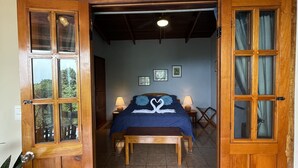 A room with a bed, two bedside lamps, a wooden bench, and a sign above the door reading "Brian's Sports & Smoking Room". - Gorgeous Views of Pacific and Rainforest (manuel antonio)