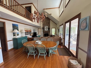 A spacious living area with a dining table, chairs, a fireplace, and a view of the outdoors. - Near Dam-Lake Front Estate w/ Large Dock, Private Ramp, and Beautiful Sunsets (Lexington)