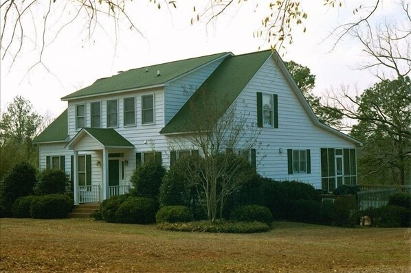 A two-story house with a green roof, white siding, and a front porch. - Near Dam-Lake Front Estate w/ Large Dock, Private Ramp, and Beautiful Sunsets (Lexington)