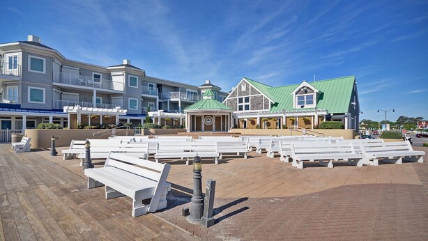 A beachfront hotel with multiple buildings, a boardwalk with benches, and a gazebo. - Luxury Bethany Beach House - 1 Block from the Beach! (Bethany Beach)
