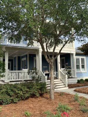 Traditional home with a porch and staircase, surrounded by a well-maintained garden.