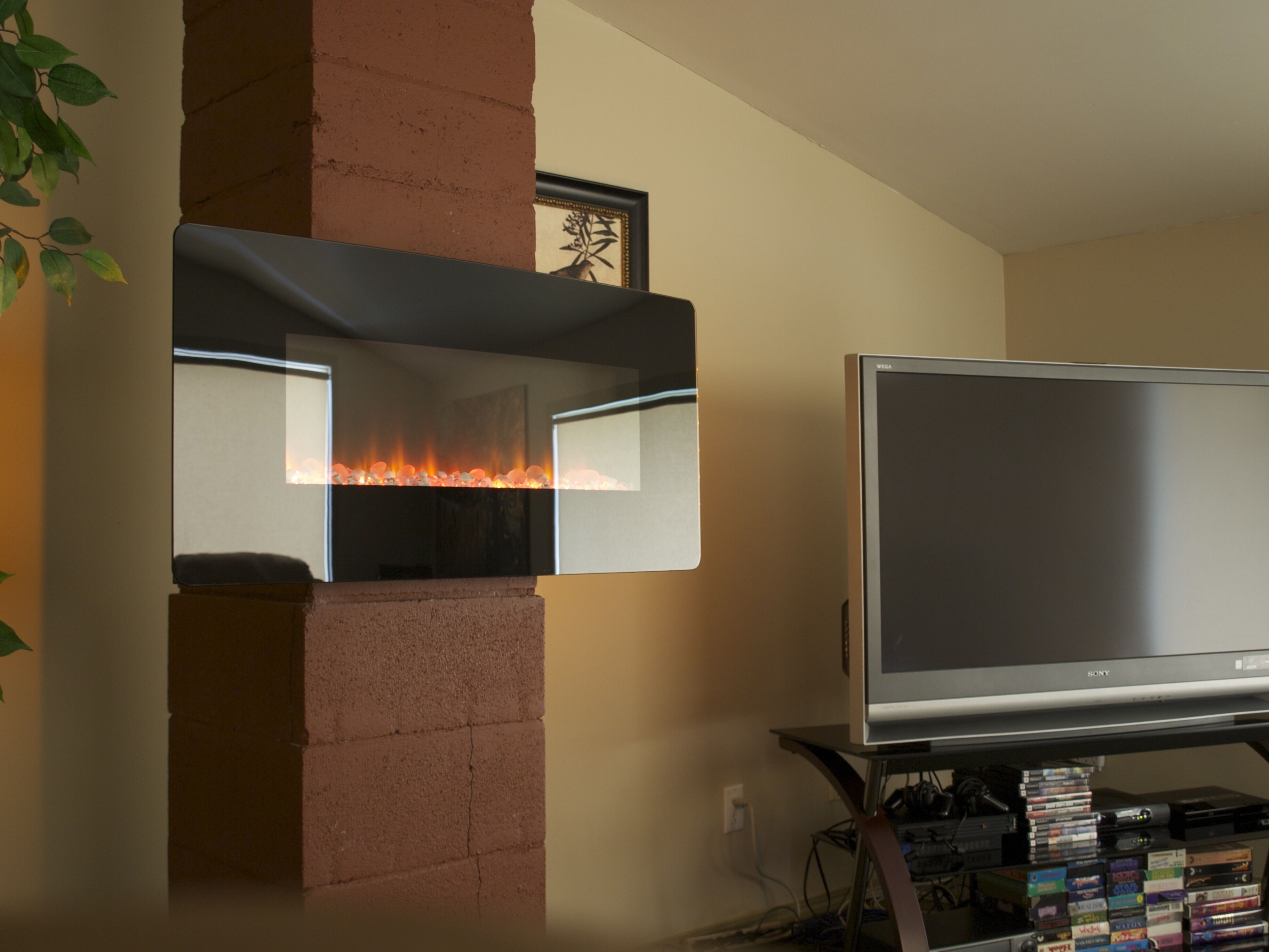 A living room with a fireplace, a flat-screen TV, and a shelf with various items.