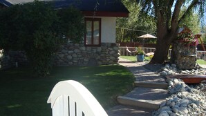 A stone house with a red roof, a paved driveway, and a white gate. - ** Ypcfitness & Accomodations ** (Invermere)