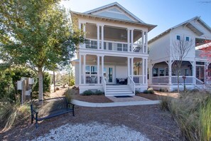A two-story house with a covered porch and a second-story balcony.