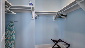 Una stanza con un muro blu, una panca di legno e uno scaffale bianco con un ferro appeso.