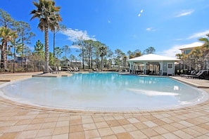 A large outdoor swimming pool with a tiled deck, surrounded by palm trees and a gazebo. - 6-Seater Golf Cart & 6 Bikes! Spacious Porches! Balconies w/ Views of the Pond! Latitude Adjustment (Santa Rosa Beach)