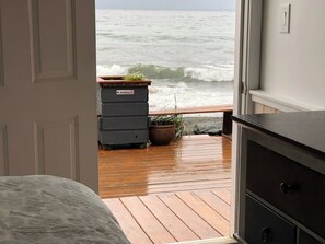 A room with a view of the ocean through an open door.