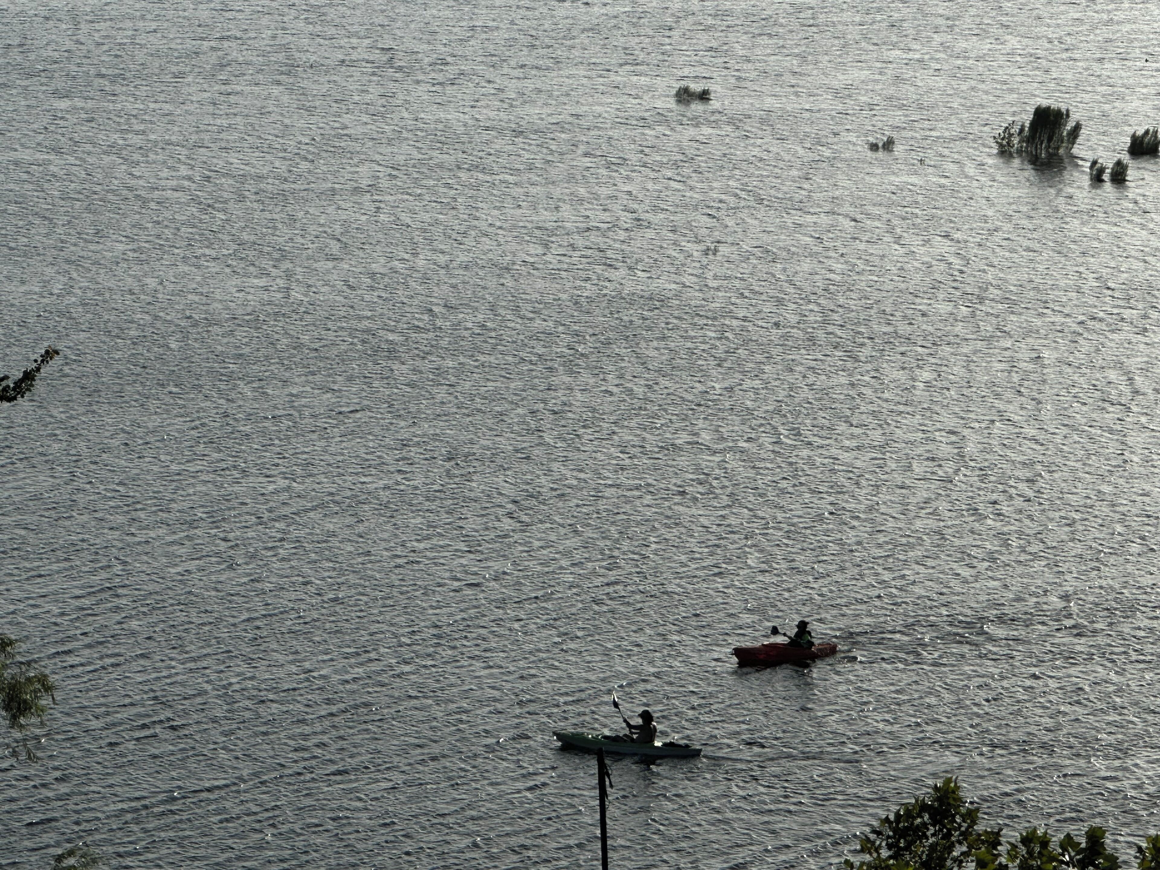 Una extensión de agua extensa con varios barcos, incluyendo un bote pequeño y un barco con motor más grande.