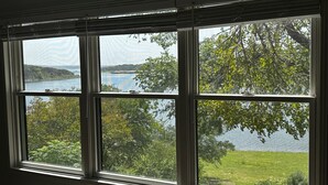 A room with a large window offering a view of a lake and surrounding greenery. - Lake Travis Waterfront Home - 4 Bed, 2 Bath, spectacular views, & private dock (Austin)