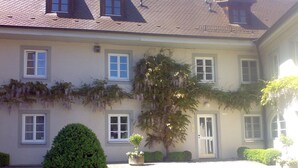 Ein zweistöckiges Gebäude mit einer symmetrischen Fassade, zahlreichen Fenstern und einem zentralen Eingang.