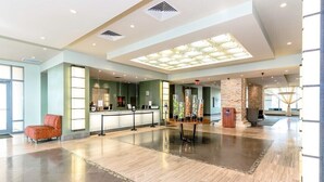 Un hall amplio con una recepción, una zona de estar y una columna decorativa.