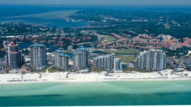 Ein Küstenresort mit mehreren Hochhäusern, einem Strand und einem Golfplatz.