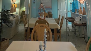 Un comedor con candelabro, mesa, sillas y un espejo.