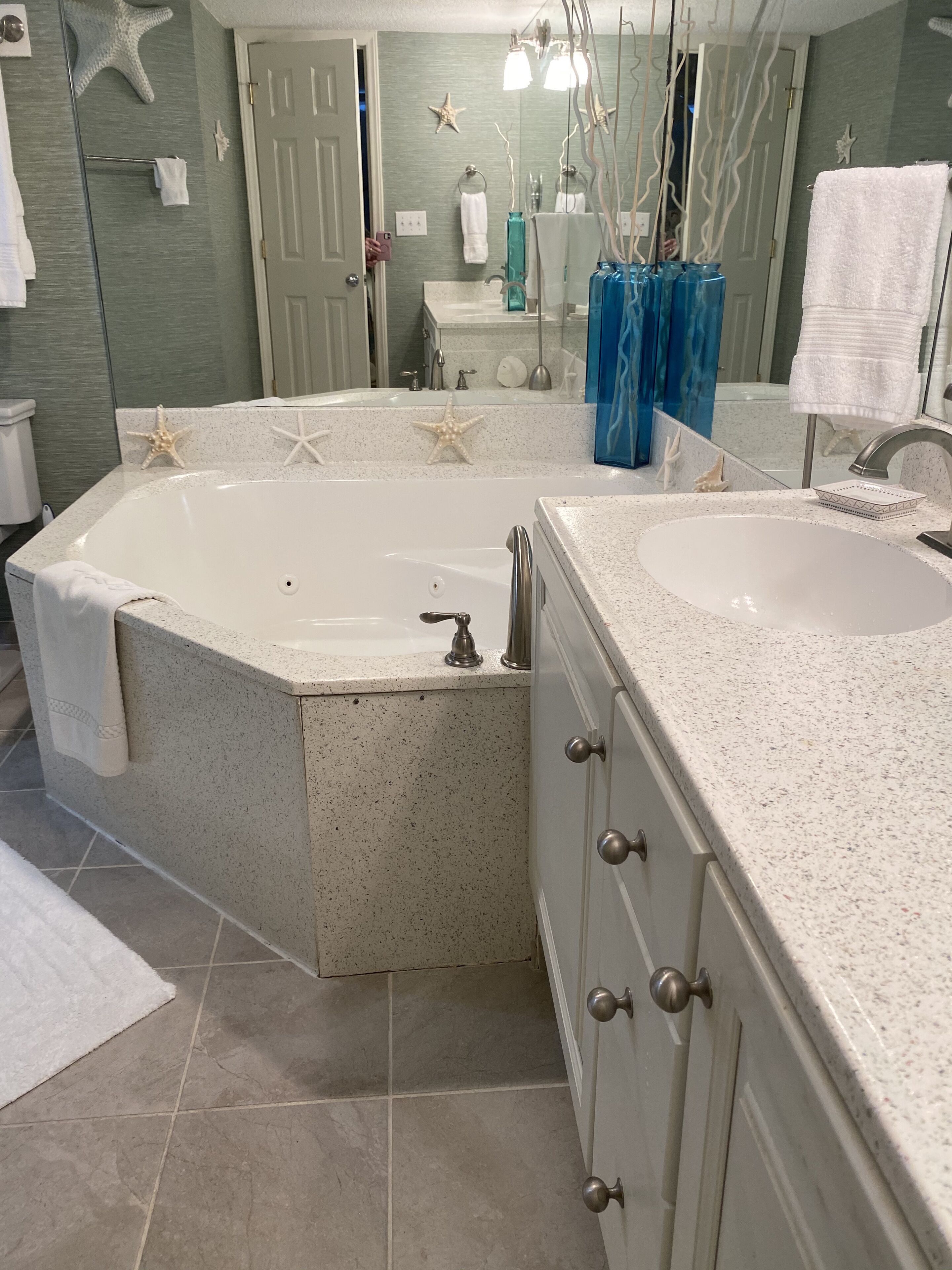 A bathroom with a freestanding bathtub, two sinks, and a vanity with drawers.