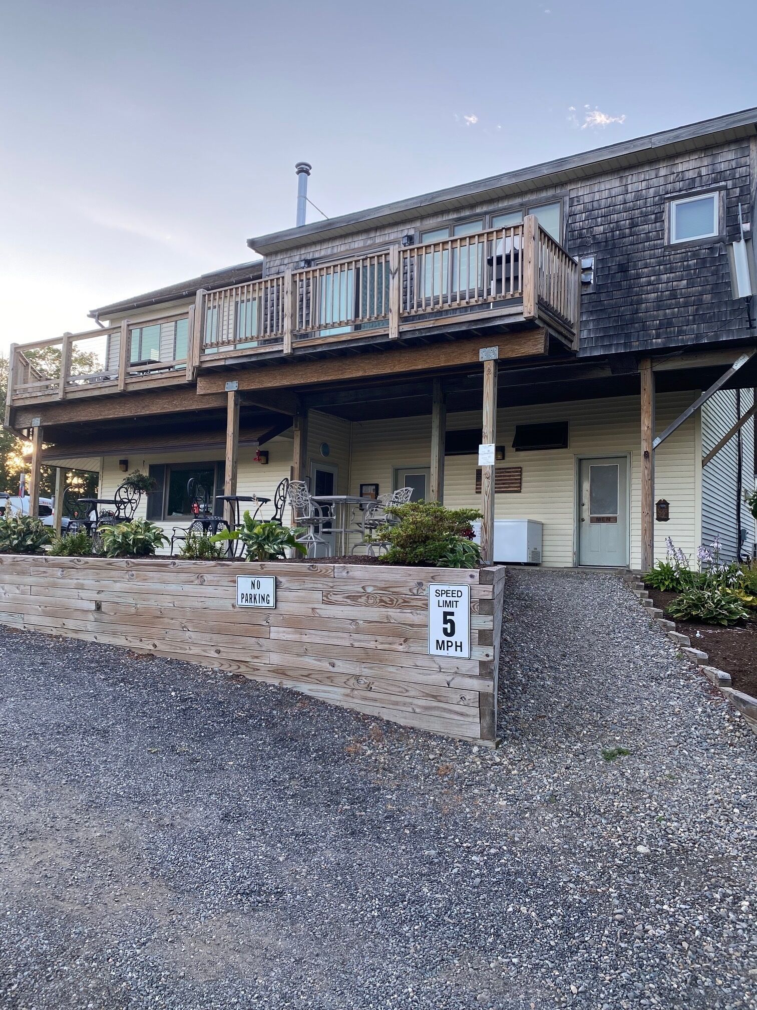 A two-story building with a covered outdoor seating area and a speed limit sign indicating 5 MPH.