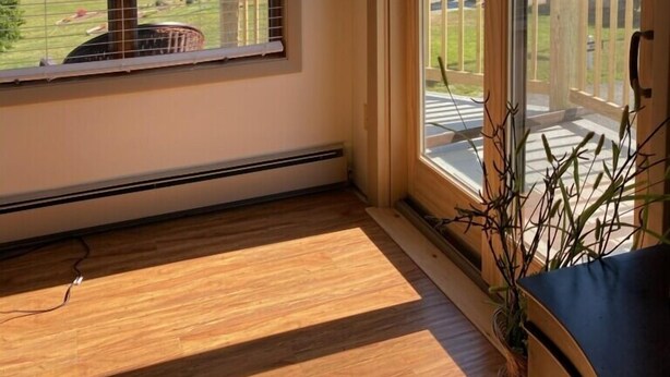 A room with large windows, a view of a lake, and a wooden floor. - Ocean View Apartment Along Maine's Scenic Penobscot Bay (Belfast)