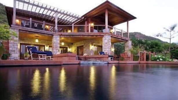 Un edificio grande de varios pisos con una piscina al frente.