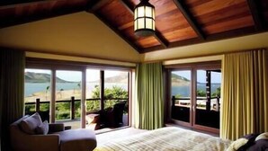 Un dormitorio con una cama grande, un sofá y vistas al mar.