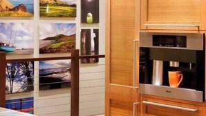 Una cocina con armarios de madera, un refrigerador de acero inoxidable y una cafetera.