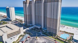 Un hotel di grattacielo con numerosi piani, piscina e vista sulla spiaggia.