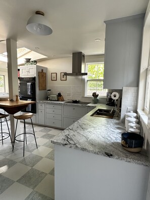 Enjoy cooking in this well-lit kitchen with an oven, stovetop, and large island with bar stools.