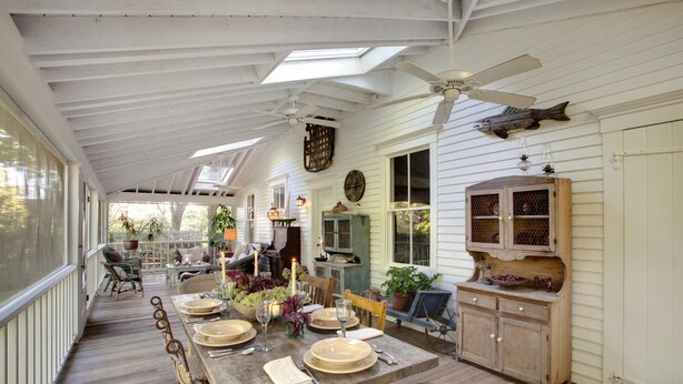 A covered patio with a dining table set for four, surrounded by wicker chairs. - Historic Captains House - Newly Renovated Primary Bathroom and Upgraded Kitchen (West Tisbury)