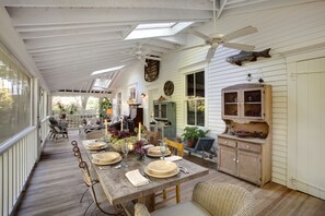 Enjoy meals in this inviting dining area with a large table, ceiling fan, and views of the outdoors.