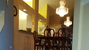 A staircase leading to a dining area with wooden flooring and a chandelier. - Centrally Located in Beautiful Naples (NAPLES)