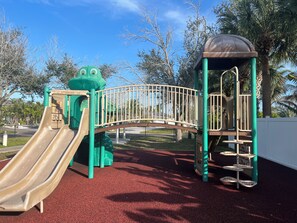 A playground with a slide, climbing structures, and a covered play area.