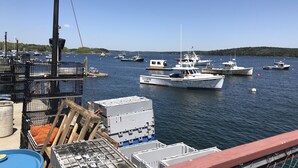 A marina with several boats docked, a crane, and various containers and equipment. - Spectacular waterfront home with panoramic views on 4 private acres ! (Harpswell)