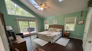A bedroom with a bed, a desk, a chair, a ceiling fan, and large windows. - Waterfront home on a quiet cove mid-lake! 4 kayaks, hot tub, and dog friendly!  (Mineral)