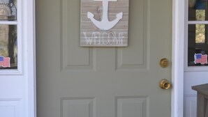 A door with a welcome sign featuring an anchor and the word "WELCOME". - Waterfront home on a quiet cove mid-lake! 4 kayaks, hot tub, and dog friendly!  (Mineral)