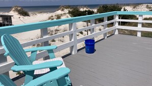 A turquoise deck with a white railing overlooking a beach with sand dunes and a clear sky. - Natural High-Amazing Beach Getaway-Privacy, Easy Access, Kayaking, Boating (Cedar Island)