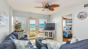 A living room with a sofa set, a television, and a ceiling fan. - Direct Gulf front View two bedroom, two bath totally refurbished. (Gulf Shores)