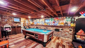A pool table in a room with wooden floors and exposed beams. - Secluded Pocono lodge, perfect for a weekend getaway with friends or family (East Stroudsburg)
