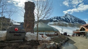 A sign for Adventure Park with a mountain backdrop.