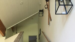 A wooden staircase with a handrail, a wall-mounted light fixture, and a door at the top. - Luxury 2 Bedroom, 2 Bath Condo - Perfect for a Fun Filled Family Get Away! (Mammoth Lakes)