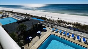 Un espace piscine offrant une vue sur la plage et l’océan.