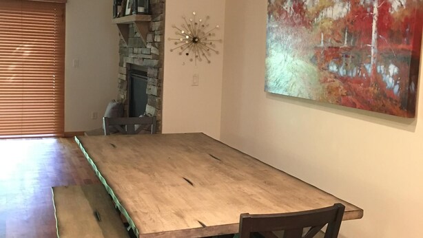 A dining area with a long wooden table, benches, and chairs. - This beautiful, spacious condo is located right off Main Street in Ouray. (Ouray)