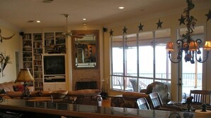 Uma sala de estar ampla com uma grande janela, lareira e televisão.