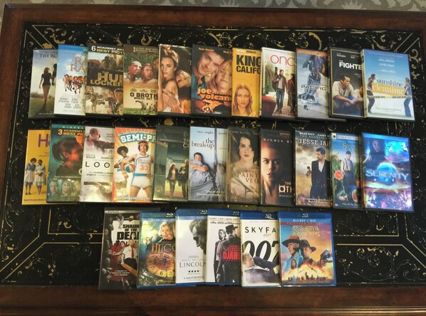 A collection of movie DVDs on a shelf.