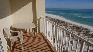 A balcony with a table and chairs overlooking a beach. - Directly on the Gulf, larger end unit,  both bedrooms have water view! (Pensacola Beach)