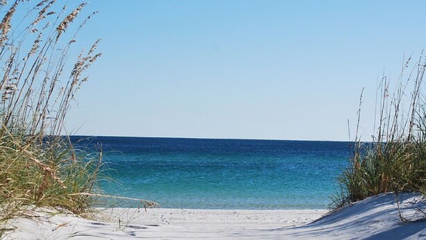 A beach with clear blue water and sand. - Directly on the Gulf, larger end unit,  both bedrooms have water view! (Pensacola Beach)