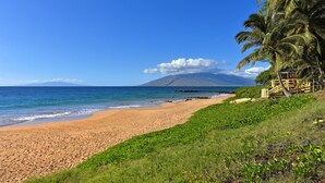 A beach with a clear view of the ocean and a mountain in the distance. - Kam Sands -Innercourt- Ocean views- large lanai & very private third floor end  (Kihei)