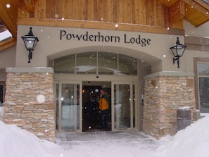 The entrance to Powderhorn Lodge with stone walls and a wooden roof.