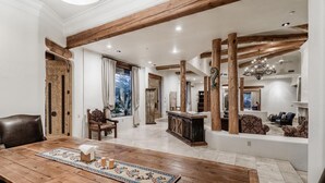 A spacious living room with a wooden dining table, a fireplace, and a large mirror. - LUXURY 5 acre Property Heated Pool ~ See our Reviews!! (Scottsdale)