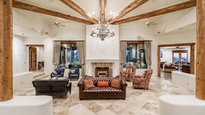 A spacious living room with a fireplace, wooden beams, and a chandelier. - LUXURY 5 acre Property Heated Pool ~ See our Reviews!! (Scottsdale)