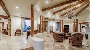 A spacious living area with high ceilings, exposed wooden beams, and a chandelier. - LUXURY 5 acre Property Heated Pool ~ See our Reviews!! (Scottsdale)